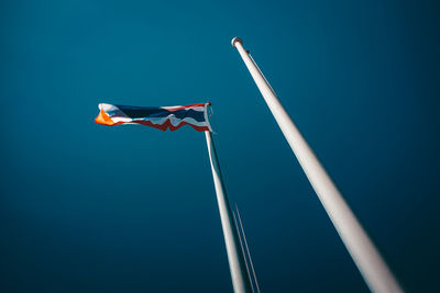 Low angle view of flag against blue sky