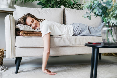 Side view of woman relaxing on sofa