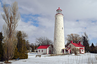 Tower by building against sky during winter