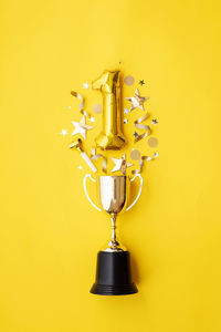 Close-up of trophy against yellow background
