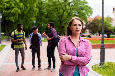 Portrait of young couple standing against trees