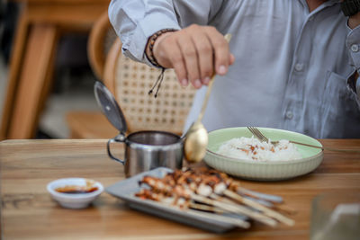 Midsection of man preparing food on table