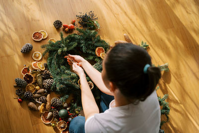 High angle view of woman standing amidst flowers on table