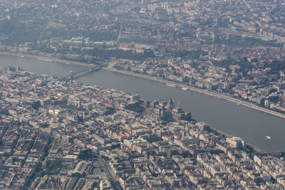 Aerial view of cityscape by river against sky