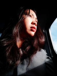 Portrait of beautiful young woman in car