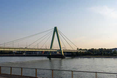 Bridge over river against sky in city