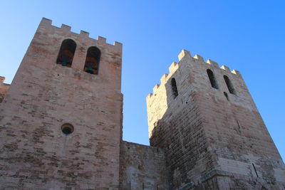 Low angle view of old building against blue sky