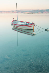 Fishing boat moored in sea against sky