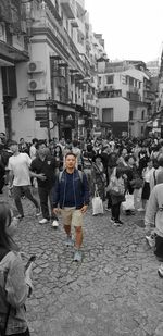 People walking on street against buildings in city