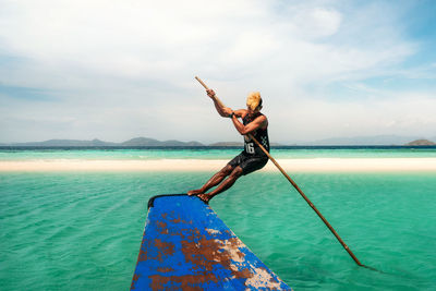 Man on boat in sea against sky