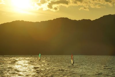 People windsurfing against the background of the setting sun over biwako lake
