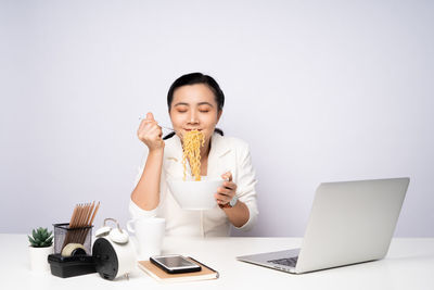 Mid adult man using smart phone while sitting on table