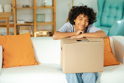 Young woman using digital tablet while sitting on sofa at home