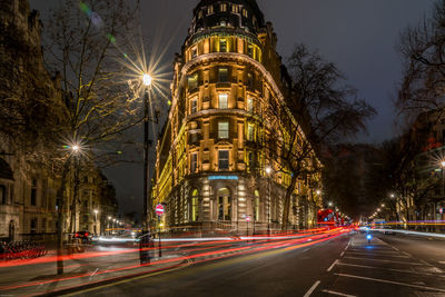 Illuminated light trails on city street at night