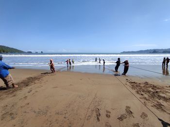 People on beach against sky