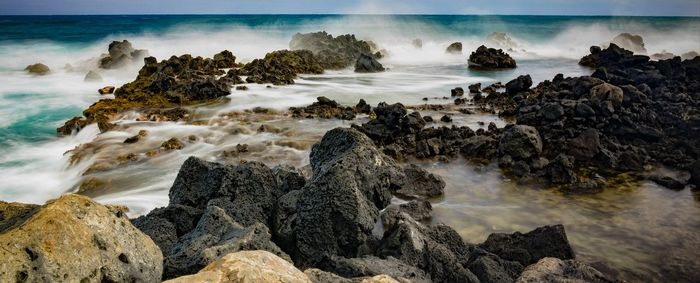 Rocks on beach against sky