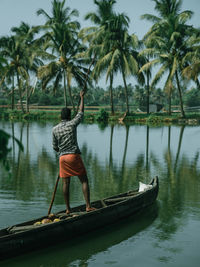 Rear view of man kayaking in lake