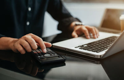 Midsection of man using laptop on table