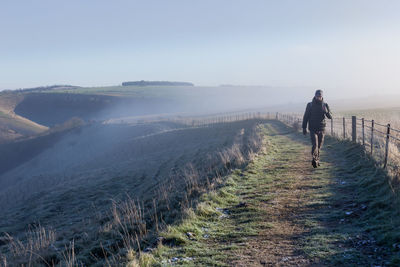 Full length of man walking on land against sky