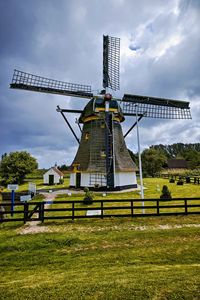 Traditional windmill on field against sky
