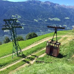 Overhead cable car on field against mountains