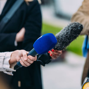 News reporters interviewing a person at a local media conference