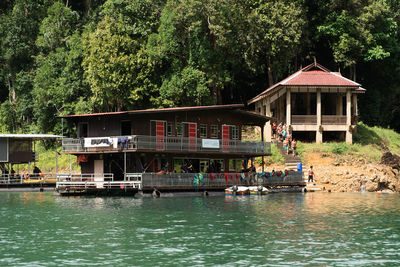 Built structure by lake against trees