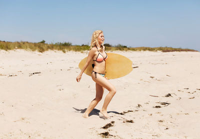 Full length of woman on beach against sky