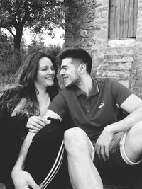 Smiling young couple sitting outdoors