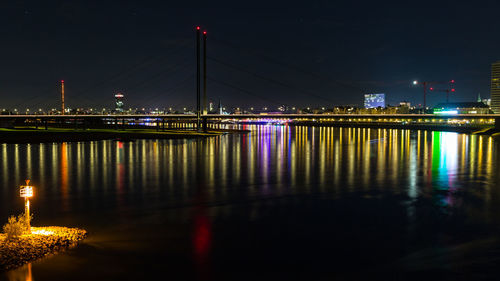 Illuminated waterfront river rhein in düsseldorf at night reflecting in the water