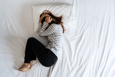High angle view of woman lying down on bed