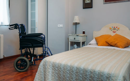 Wheelchair by bed in bedroom