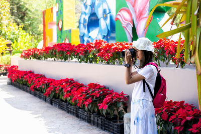 People standing by flowering plants