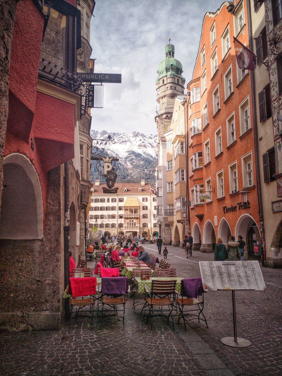 CHAIRS AND TABLES AT SIDEWALK CAFE AGAINST BUILDINGS