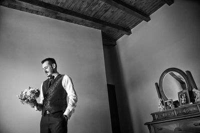 Portrait of young man standing against wall