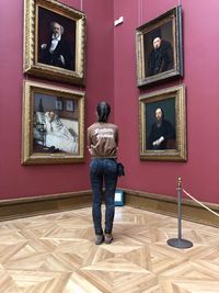 Full length of woman standing against wall in museum