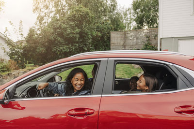 Happy family having fun in electric car during road trip