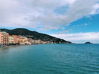 Scenic view of sea by buildings against sky