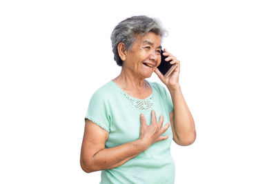 Senior woman talking on smart phone against white background