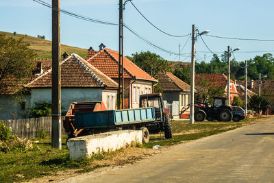 Road by buildings against clear sky