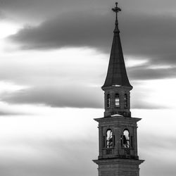 Bell tower with tin roof and cloudy sky in the background in camporovere, asiago, vicenza, italy