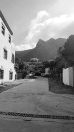 Houses on mountain against cloudy sky