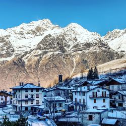 Houses on snowcapped mountain against sky