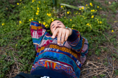 Moroccan man laying on the ground and holding his hand up to the camera