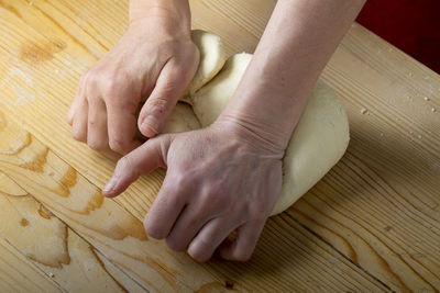 Cropped hands preparing pasta dough on table