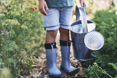 Low section of woman standing by plants