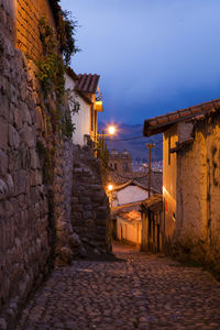 Street amidst buildings against sky at night