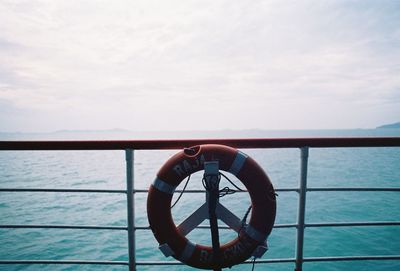Life belt against railing of nautical vessel on sea