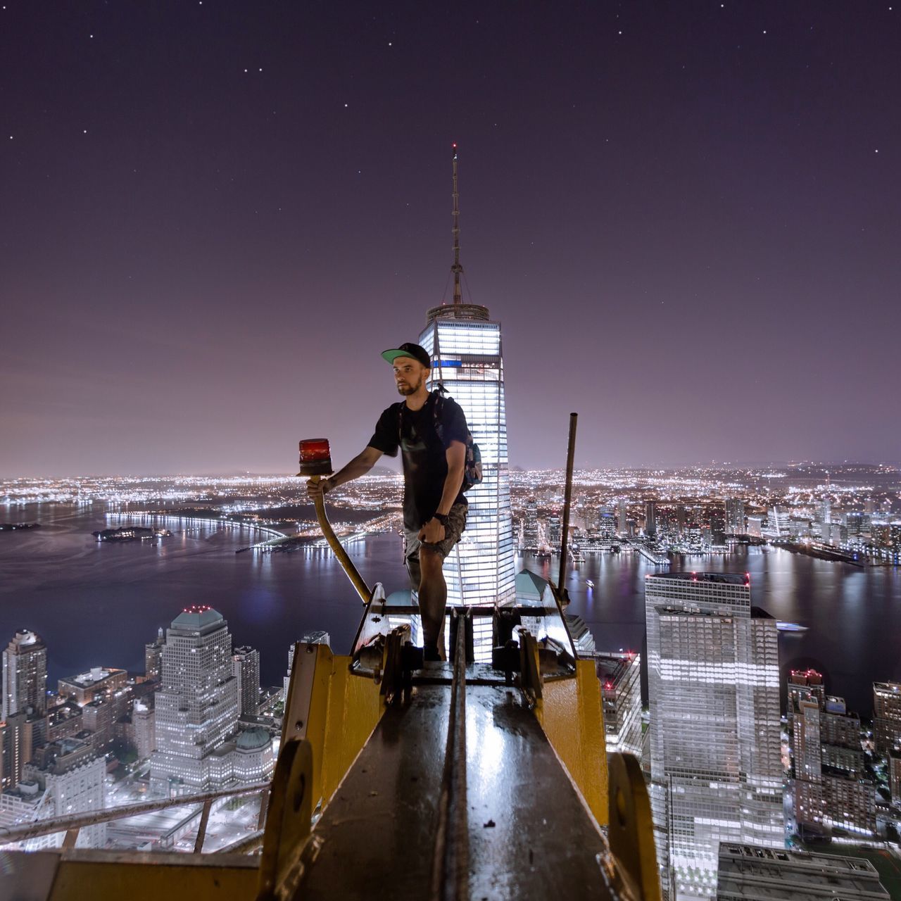 building exterior, city, night, cityscape, illuminated, built structure, architecture, sky, lifestyles, men, leisure activity, water, city life, river, clear sky, full length, standing, nautical vessel