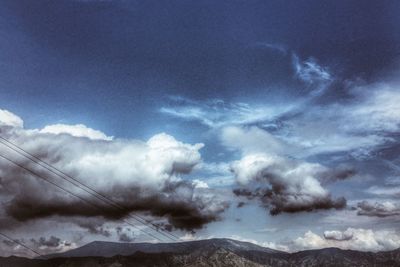 Scenic view of mountains against cloudy sky